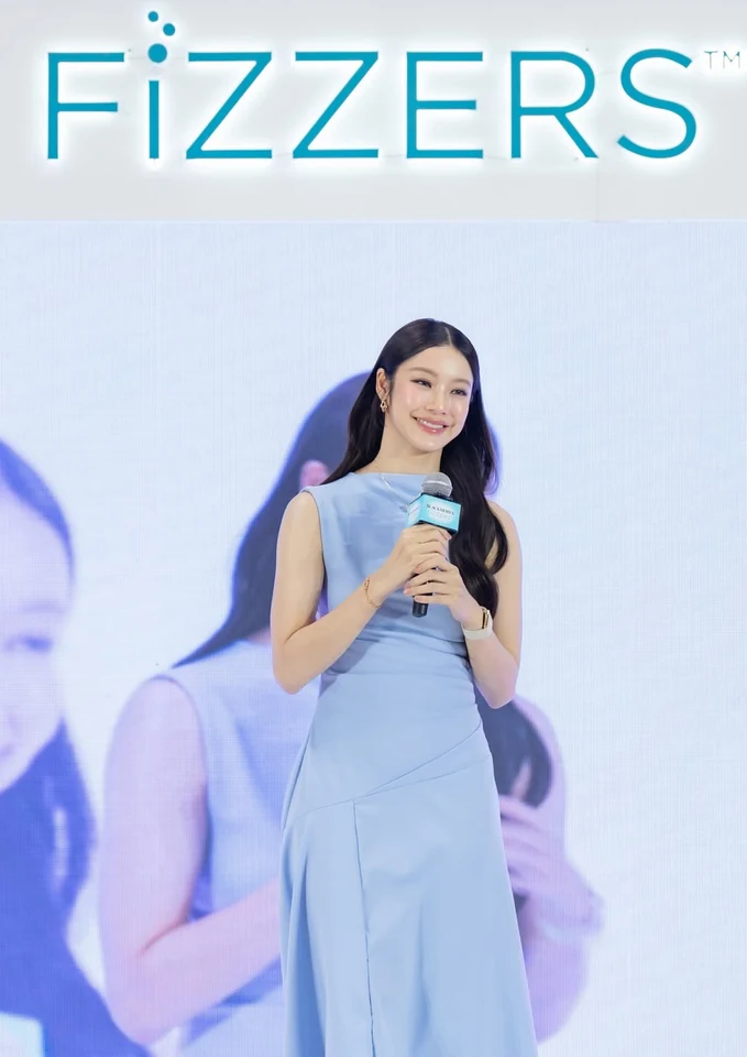 น้ำตาล ทิพนารี ถือไมโครโฟนในชุดเดรสสีฟ้าระหว่างร่วมงานอีเวนต์